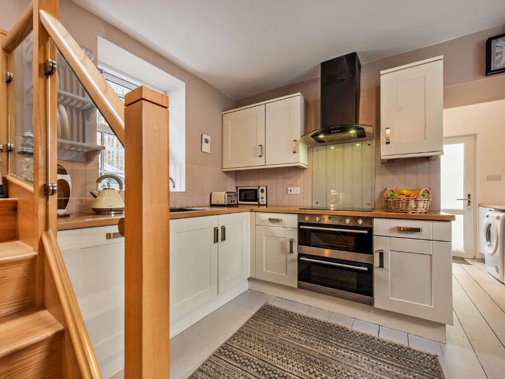 - une cuisine avec des placards blancs et une cuisinière dans l'établissement 2 Bed in Neyland 43430, à Llanstadwell