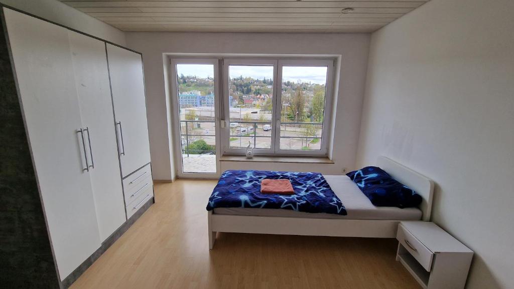 um quarto com uma cama e uma grande janela em Rooms & Apartments Schwäbisch Gmünd em Schwäbisch Gmünd