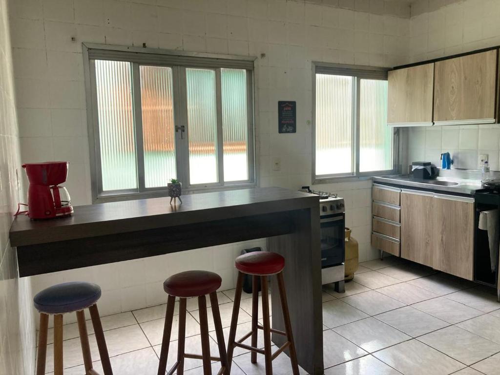 a kitchen with two bar stools and a counter top at Apartamento em Passo Fundo in Passo Fundo