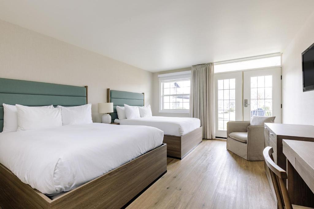 Habitación de hotel con 2 camas y sofá en Ramada by Wyndham Penticton Hotel & Suites, en Penticton