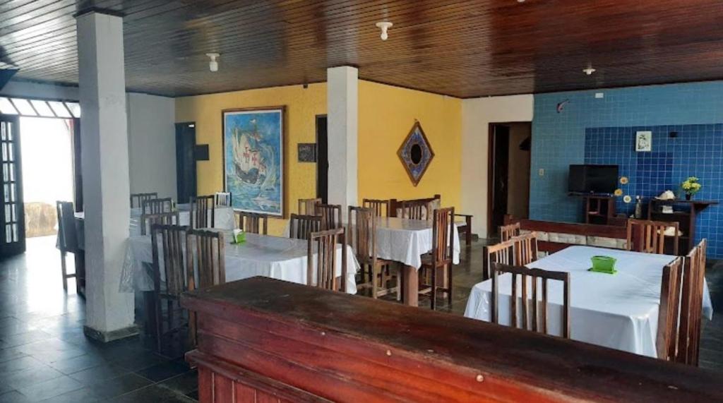 a restaurant with tables and chairs in a room at Pousada Tubarão in Camaçari