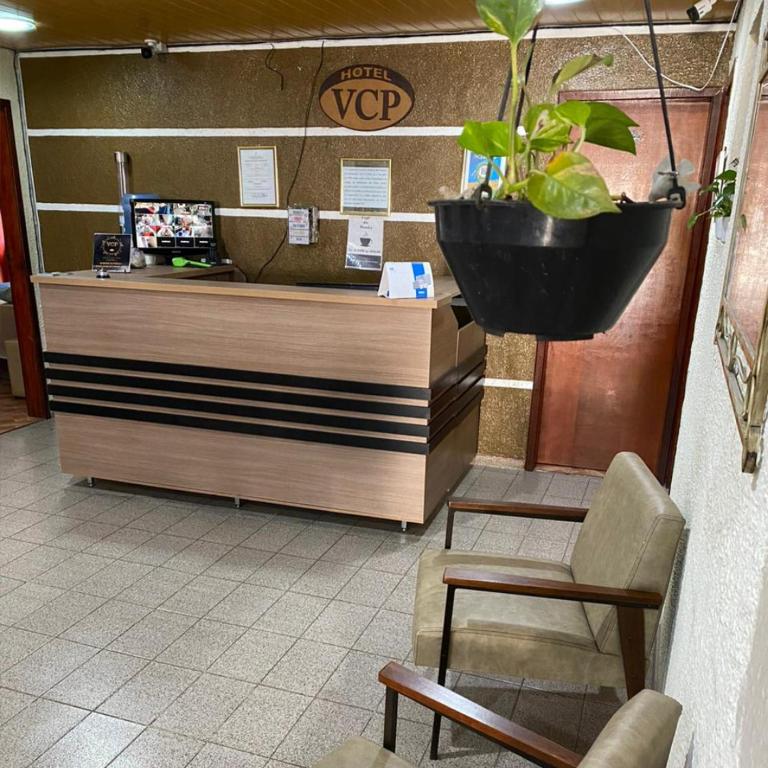 una caja registradora con una maceta en una tienda en Vitória Center Plaza Praça, en Nova Friburgo