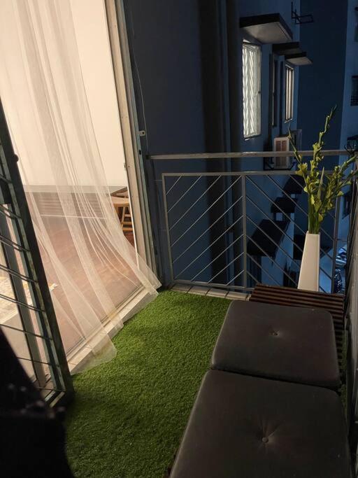 a room with a balcony with a green carpet at Palladium APT / 5mins LRT Damai in Kuala Lumpur