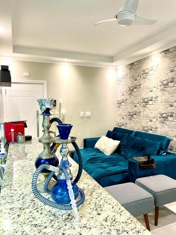 a living room with a blue couch and a table at Studio 219 em Santos in Santos