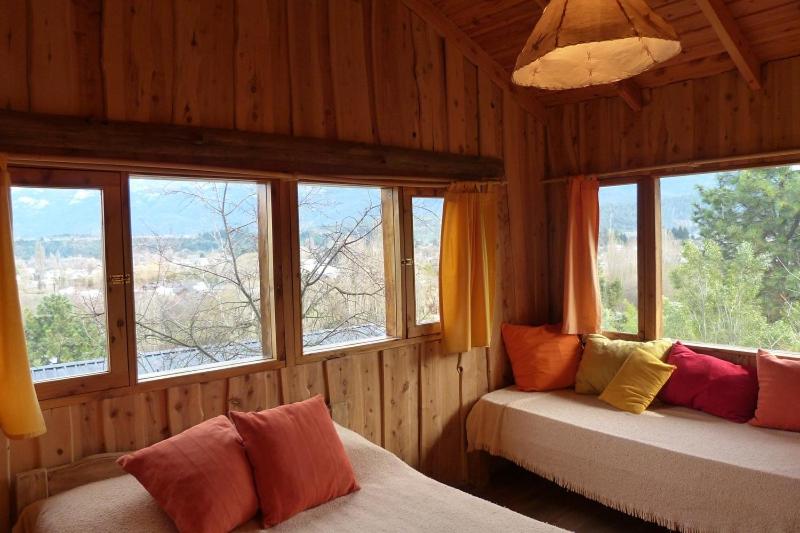 a room with two beds in a room with windows at Cabañas Cerro Amigo in El Bolsón