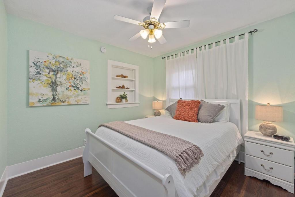 a bedroom with a white bed and a ceiling fan at Newly Renovated in the Heart of Historic Loveland in Loveland