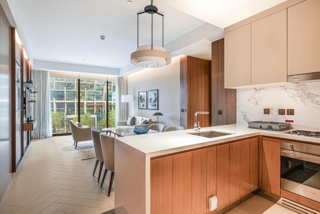 a kitchen with wooden cabinets and a dining room at Luxury 1BR The Address Opera, Downtown Dubai in Dubai