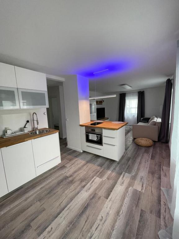 a kitchen with white cabinets and a blue ceiling at FeWo Style in Balingen
