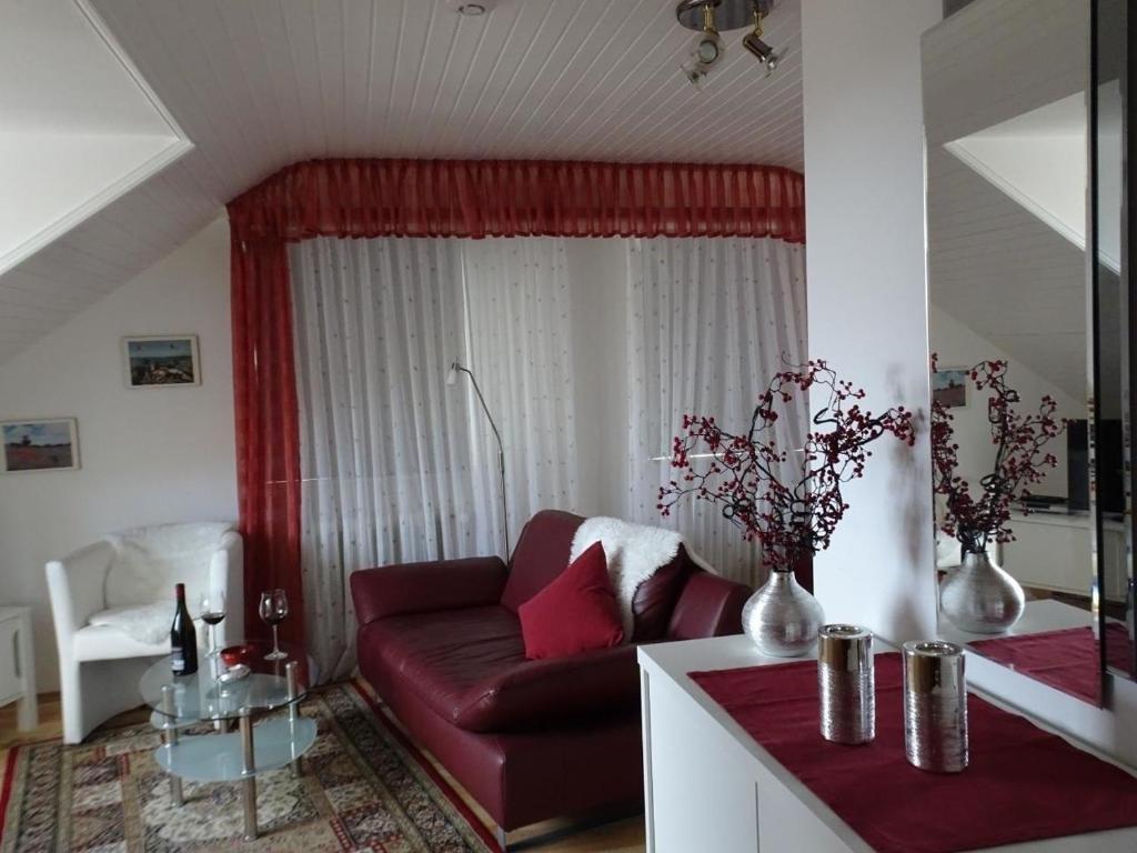 un soggiorno con divano rosso e tavolo di Haus Holzheimer mit dem einzigartigen Blick auf Bad Kissingen und die Rhön - b43286 a Bad Kissingen