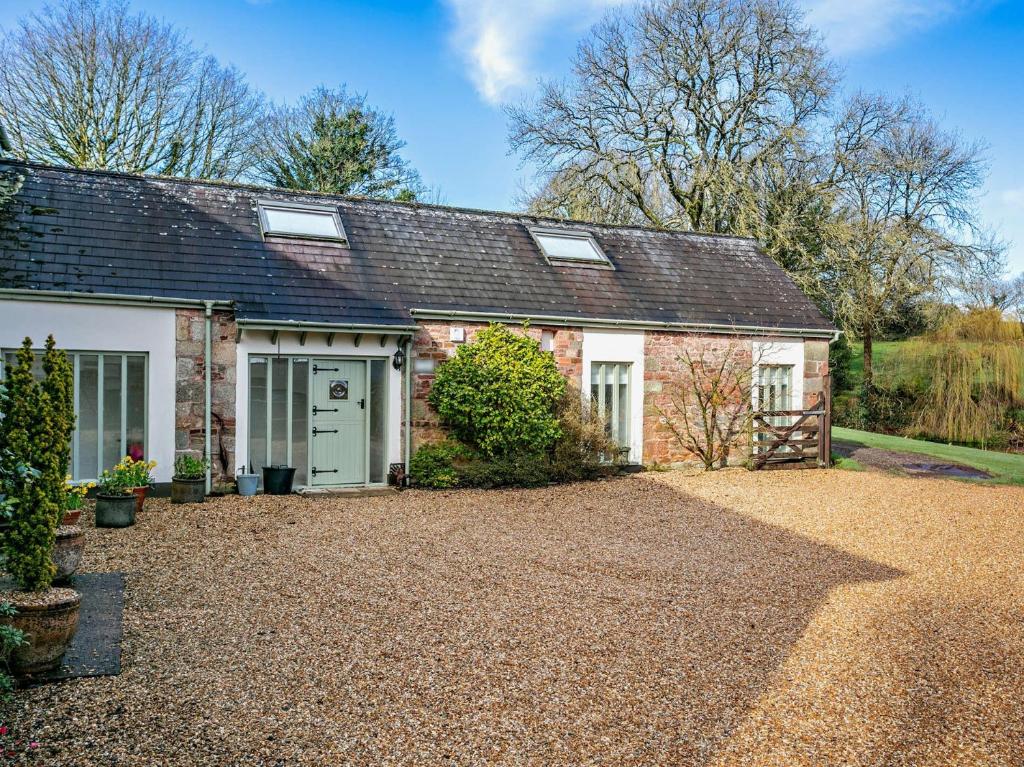 an old brick house with a gravel driveway at 3 bed in Okehampton 49513 in Sampford Courtenay