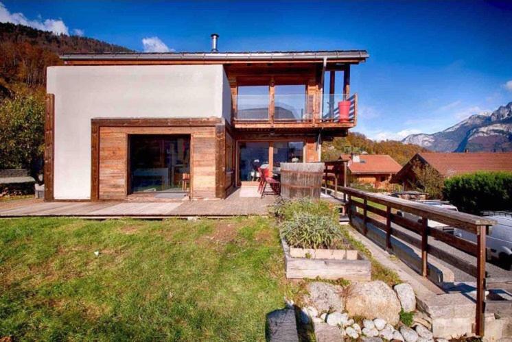 a house on a hill with mountains in the background at K'banalours in Sallanches