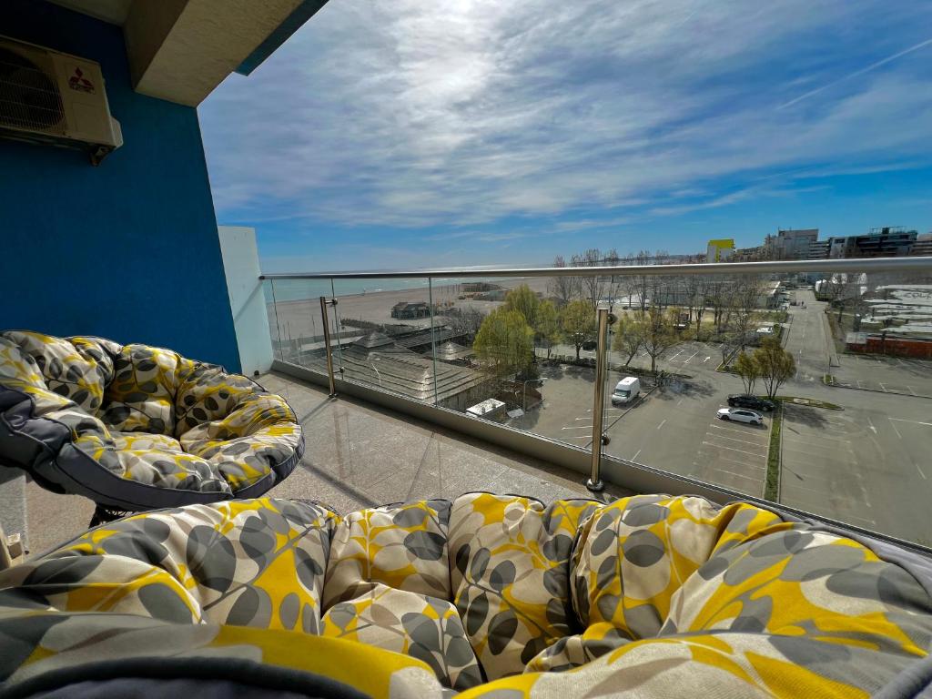 einen Balkon mit 2 Betten und Blick auf einen Parkplatz in der Unterkunft BLUEMARINA SUMMERLAND SEA VIEW STUDIOS in Mamaia