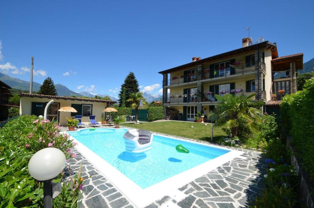 a villa with a swimming pool in front of a building at Großzügiges Ferienhaus mit hohem Komfort auf Gartengrundstück mit Pool fast direkt am See in Colico