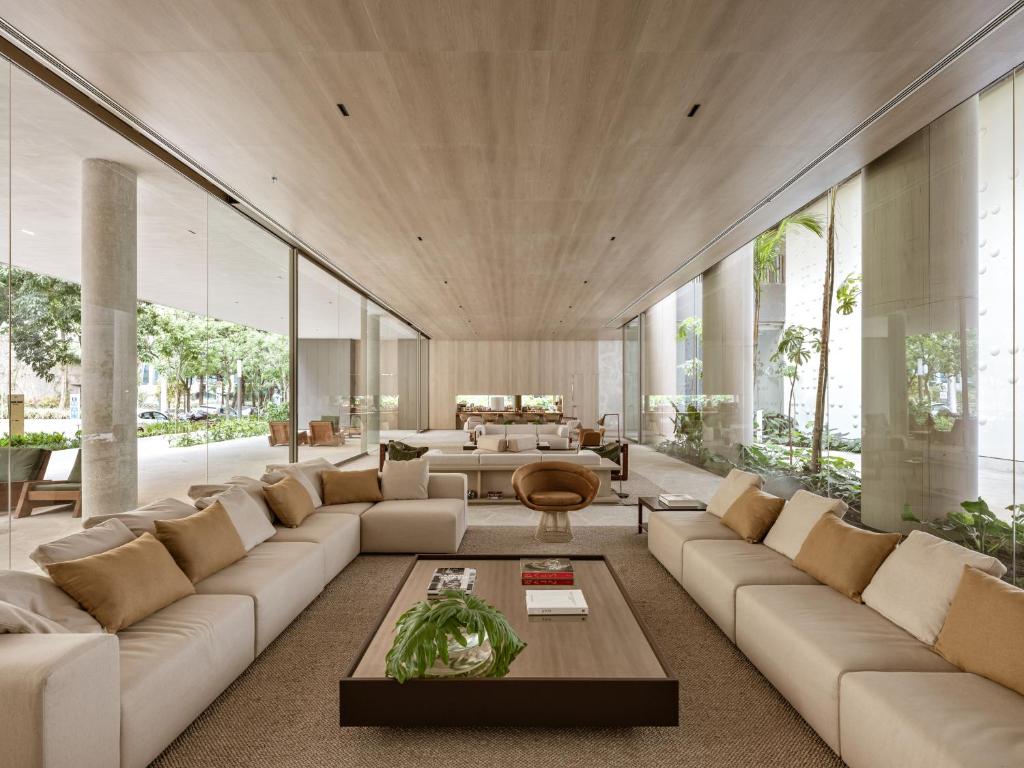 a living room with a large couch and a table at Pulso Hotel Faria Lima in Sao Paulo