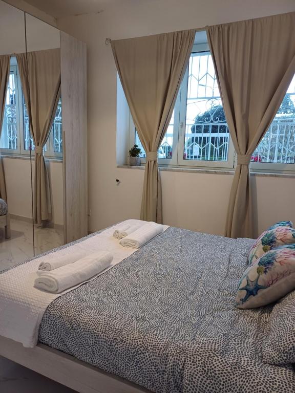 a bedroom with a large bed with windows at Casa Gimaga in Pozzuoli