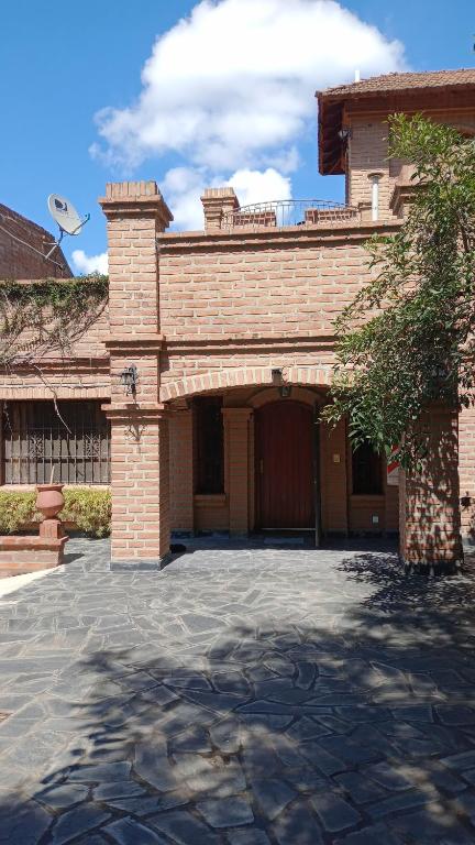 un grand bâtiment en briques avec un grand garage dans l'établissement Alojamiento Los Amigos, à Vaqueros