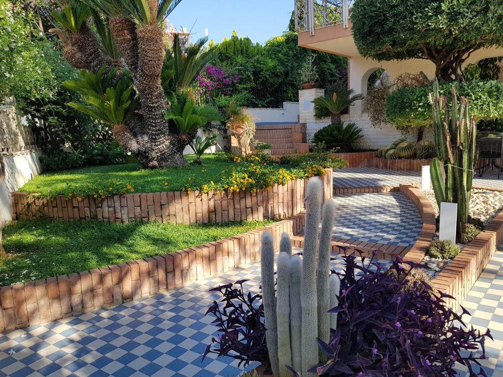 um jardim com uma cerca e árvores e uma casa em Lo Scalo 2.0 em Marina di Ragusa