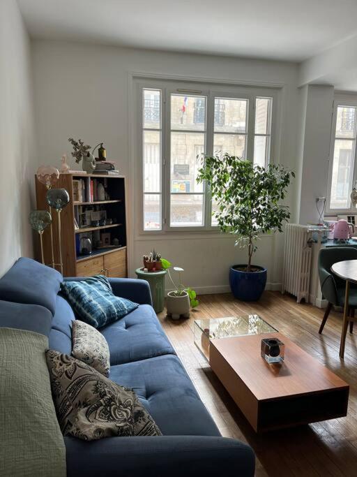 un salon avec un canapé bleu et une table dans l'établissement Calm apartment in great location, à Paris