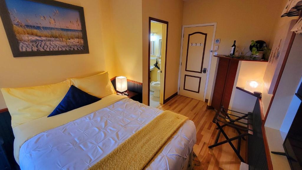 a bedroom with a bed and a door to a bathroom at Kokomo INN Bed and Breakfast Ottawa-Gatineau's Only Tropical Riverfront B&B on the National Capital Cycling Pathway Route Verte #1 - for Adults Only - Chambre d'hôtes tropical aux berges des Outaouais BnB #17542O in Ottawa