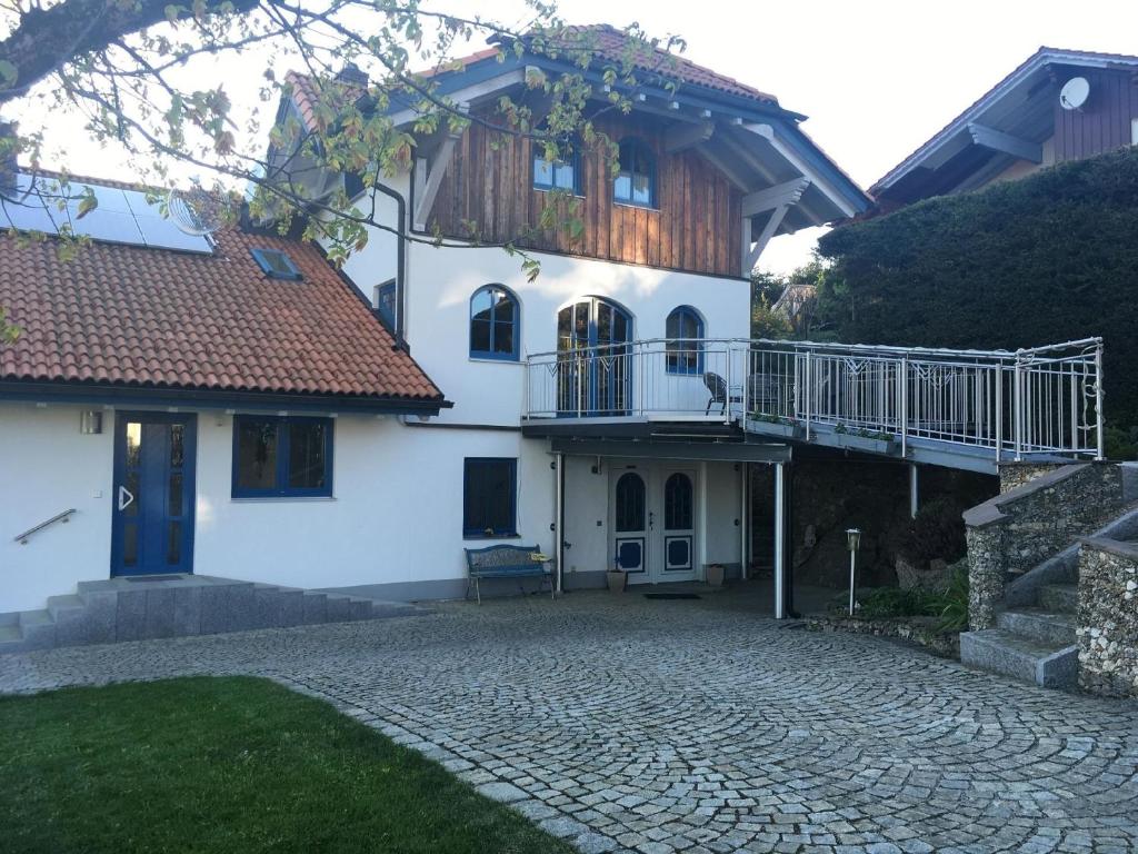 a white house with a balcony and a patio at Ferienwohnung für 2 Personen ca 80 qm in Altreichenau, Bayern Bayerischer Wald in Neureichenau