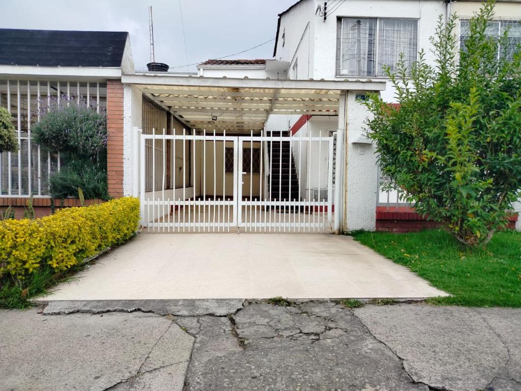 a white gate in front of a house at Hermoso departamento mejor ubicación Modelia Bta. in Bogotá