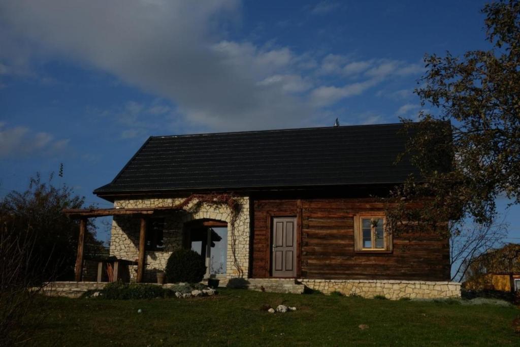 a small log cabin with a black roof at Ferienhaus in Cisowa mit gemeinschaftlichem Pool, Garten und Grill und Panoramablick in Cisowa