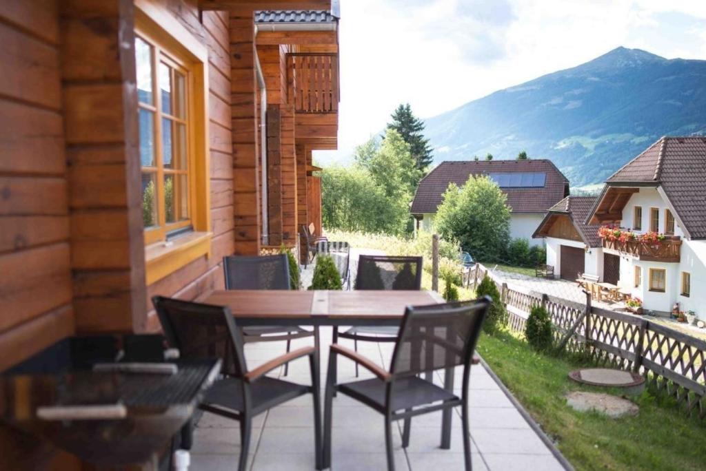 a patio with a table and chairs on a balcony at Skihütte Almhütte Tschaneck in Sankt Margarethen im Lungau