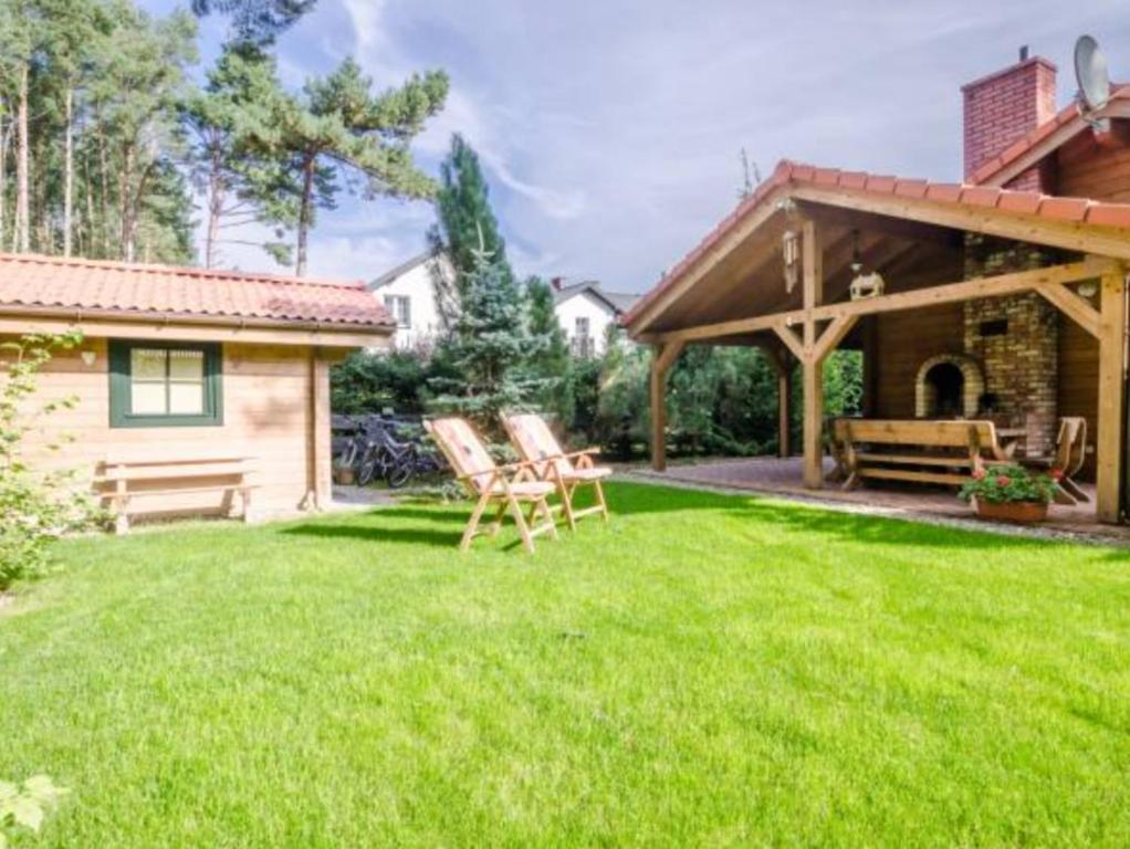 a yard with two chairs and a house at Charmantes Ferienhaus in Dbina mit Offenerem Kamin und Strand in der Nähe in Debina