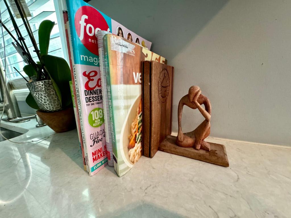 a toy monkey sitting on a shelf next to books at Zen Life Oasis in Atlanta