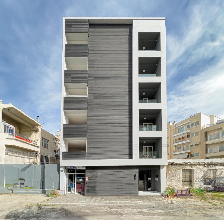 ein großes Apartmenthaus mit einer grauen und weißen Fassade in der Unterkunft Athenian boutique apartments in Athen