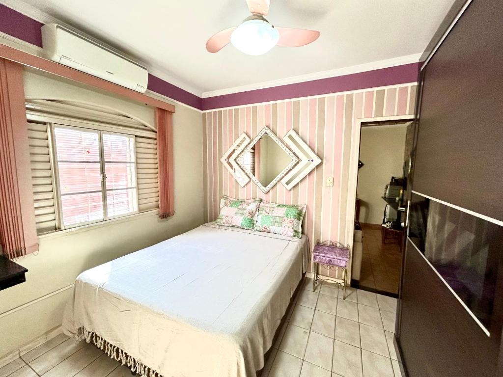 um pequeno quarto com uma cama e uma janela em Casa em Limeira à 1,7km da Unicamp em Limeira