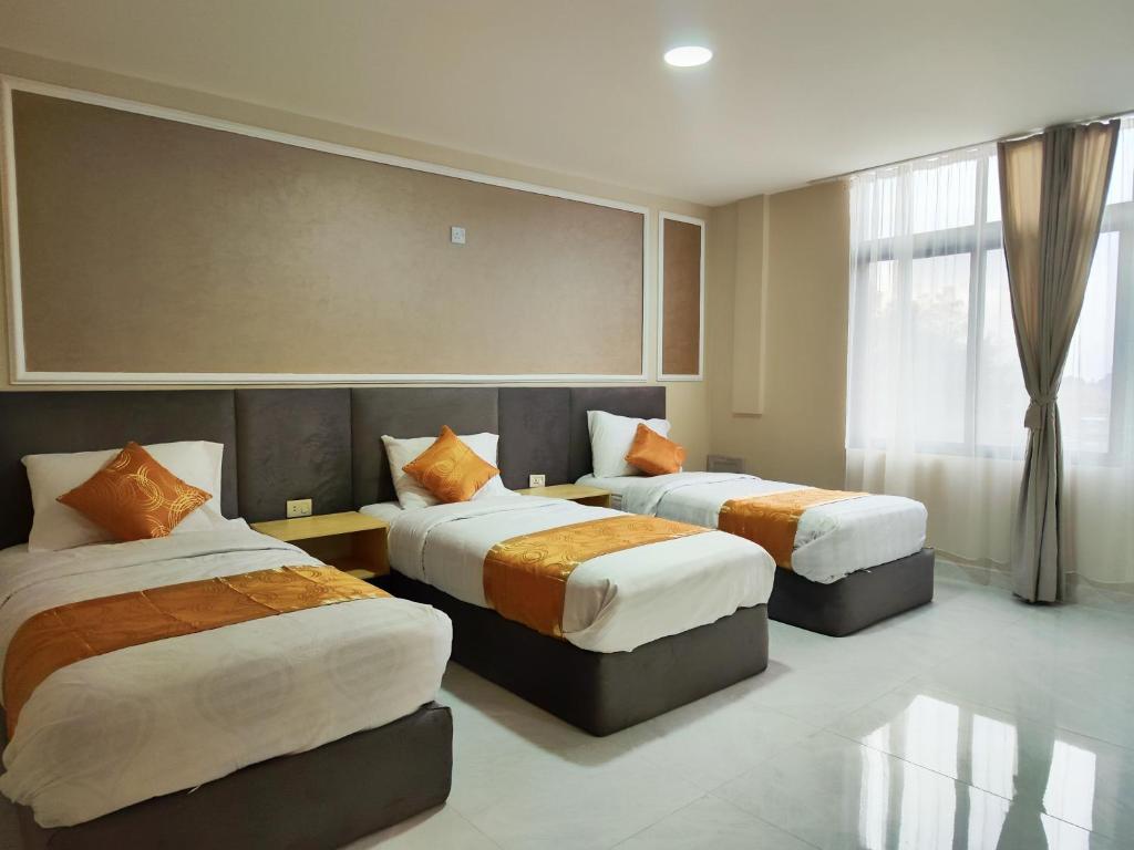 a hotel room with two beds and a window at Rakan ApartHotel and Luxury Rooms in Wadi Musa