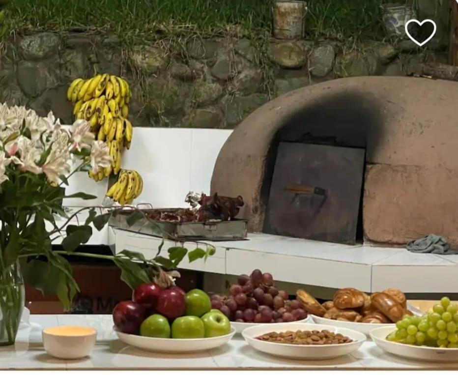 uma mesa com pratos de fruta e um forno de pizza em Terra Encantada em Maranura