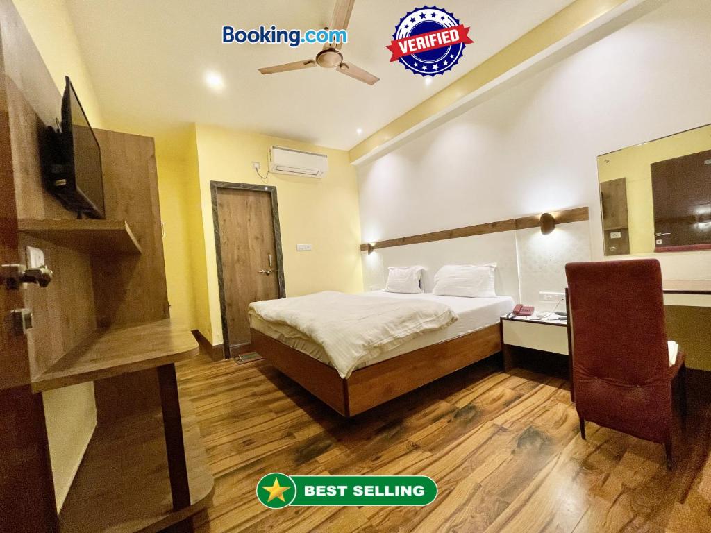 Habitación de hotel con cama y TV en Hotel SHIVAM ! Varanasi Forɘigner's-Choice ! fully-Air-Conditioned-hotel, lift-and-Parking-availability near-Kashi-Vishwanath-Temple and-Ganga-ghat en Varanasi