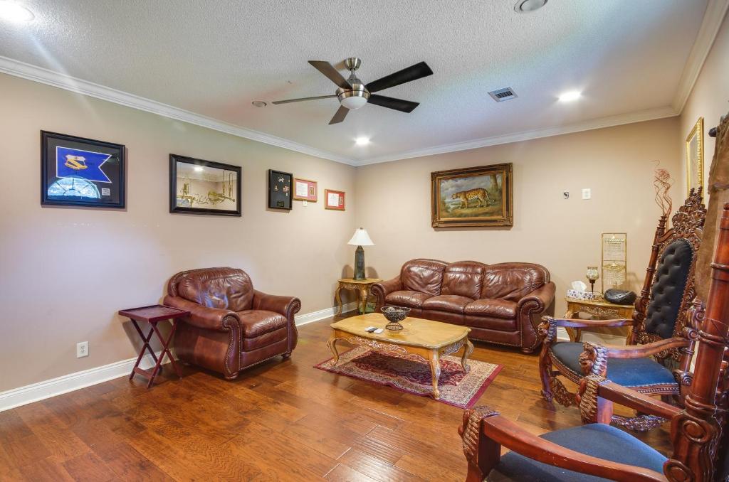 a living room with leather furniture and a ceiling fan at Homey Greenwood Getaway with Patio and Backyard in Greenwood