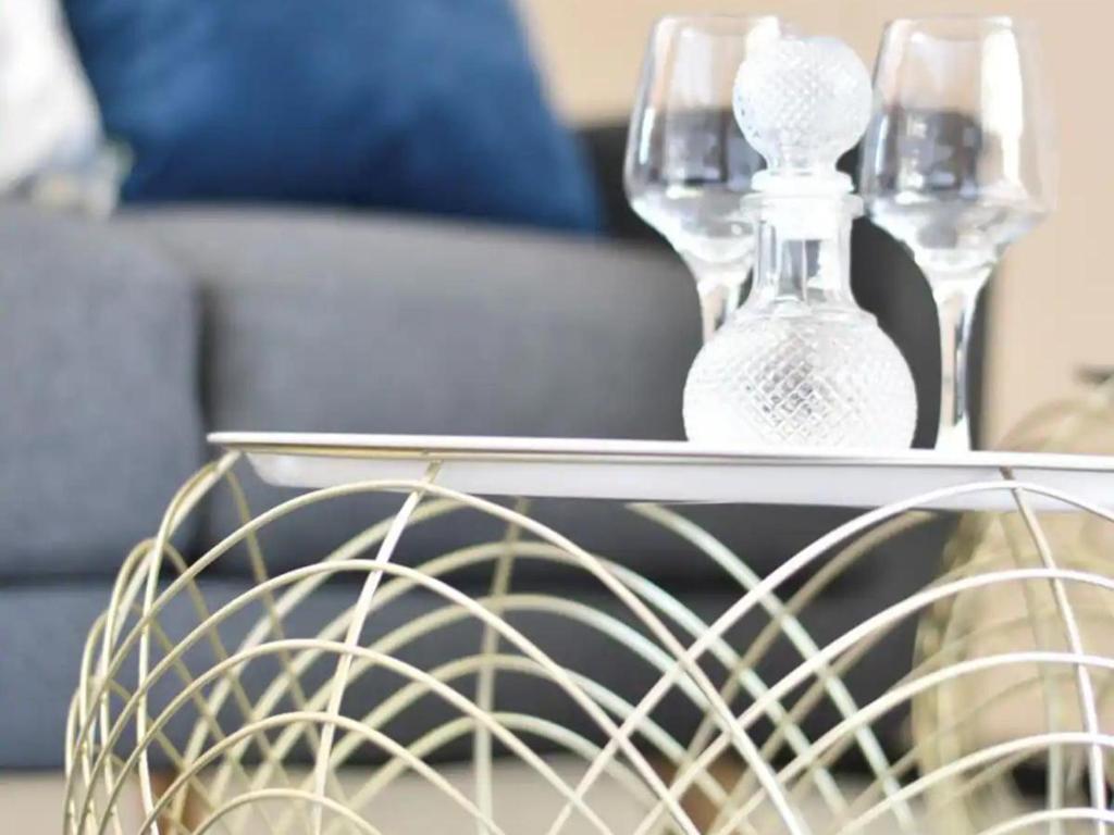 una mesa con dos jarrones de cristal encima en Lea's Furnished Apartments - Lofts at Loftus en Pretoria