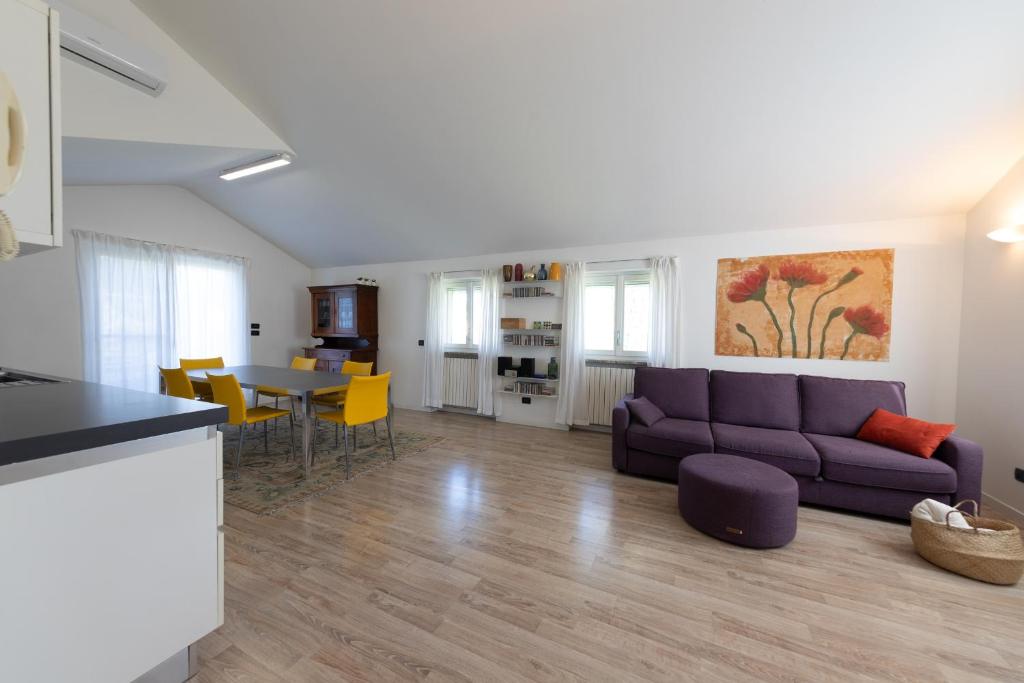 een woonkamer met een paarse bank en een tafel bij Casa Vecchia Quercia in Assago