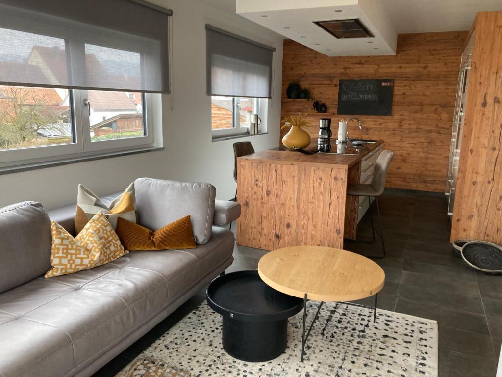 ein Wohnzimmer mit einem Sofa und einem Tisch in der Unterkunft Apartments Bogner in Marktbergel