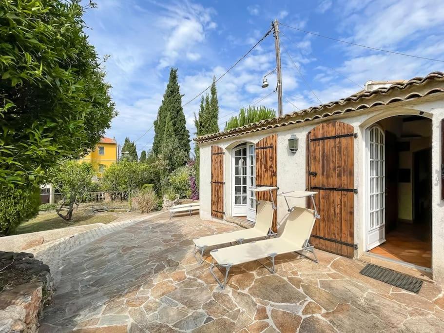 un patio con una silla y una puerta de madera en Charmante Villa au Calme Absolu, en Niza