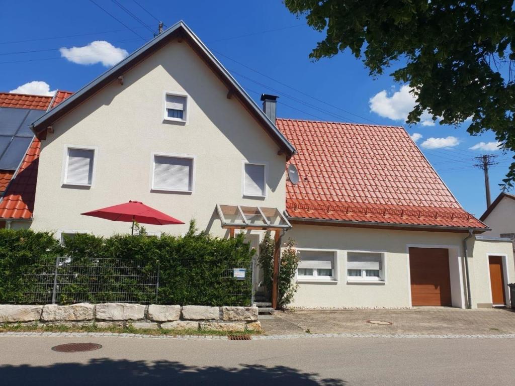 een wit huis met een rood dak bij Wunderschönes Ferienhaus in Zainingen mit Eigener Terrasse in Zainingen