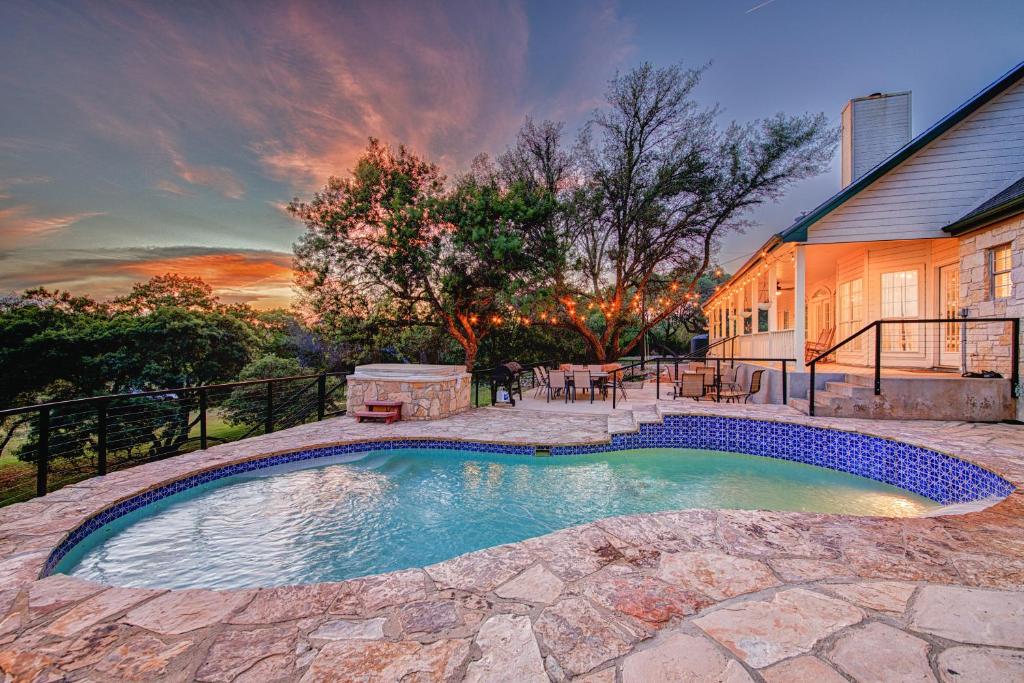 a swimming pool in the backyard of a house at Modern Farmhouse with Private Pool in Dripping Springs