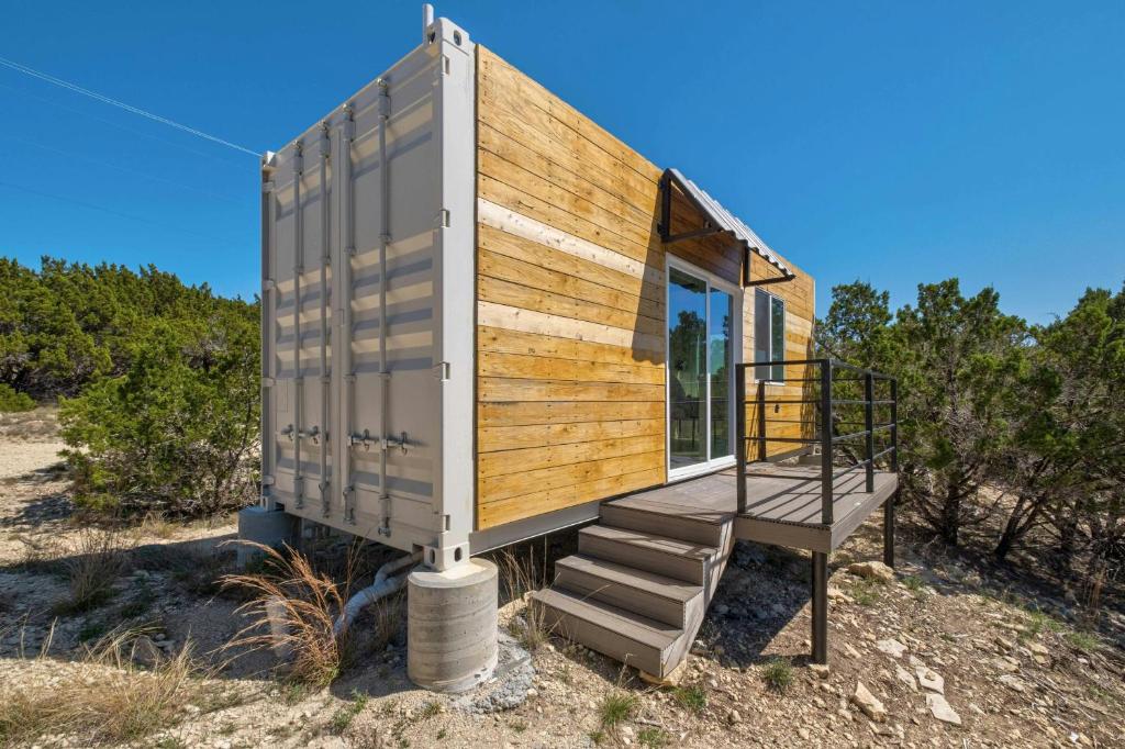 een klein huisje bovenop een veld bij Hill Country Norwood Tiny Home A- On 13 Acres & Sleeps 2 and Pet Friendly! in Dripping Springs