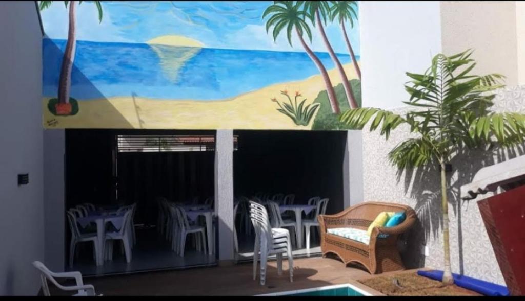 a patio with chairs and a table and a painting at Casa mobiliada para periodo TECNOSHOW in Rio Verde