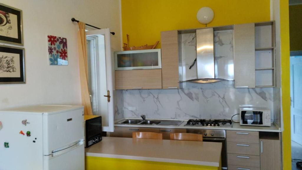 a kitchen with a white refrigerator and a sink at BILOCALE CON VISTA MARE E MON in Cala Gonone