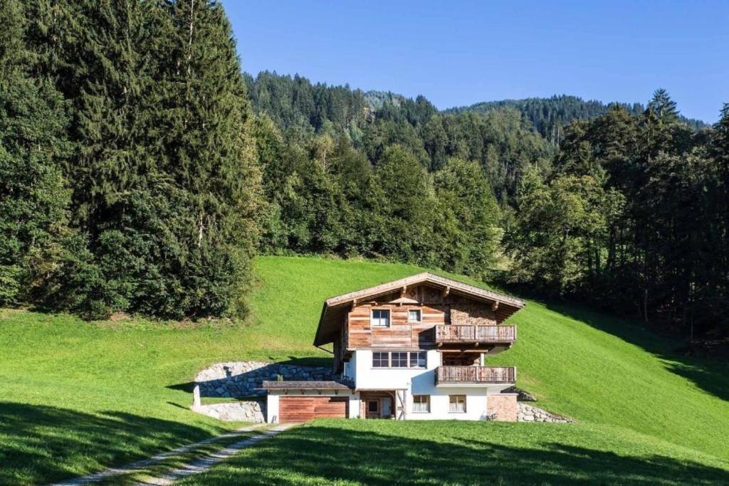 a house on a hill in a green field at Ferienhaus in Hart Im Zillertal mit Eigenem Balkon in Hart im Zillertal