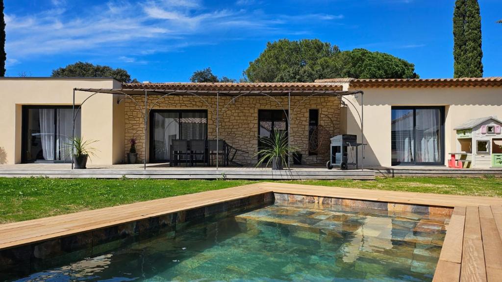 uma casa com piscina em frente a uma casa em Villa du Pont du Gard em Castillon-du-Gard