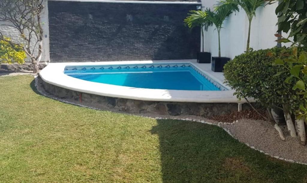 een zwembad in een tuin naast een huis bij Warrior Burgos in Emiliano Zapata