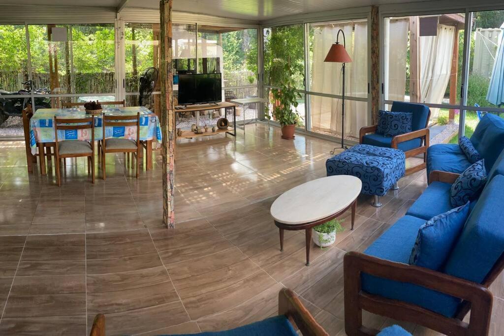 uma sala de estar com um sofá azul e uma mesa em Hermosa casa, jacuzzi climatizado em Bella Vista