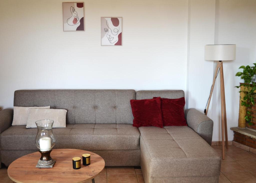 ein Wohnzimmer mit einem Sofa und einem Tisch in der Unterkunft Loupino Family House in Stoupa