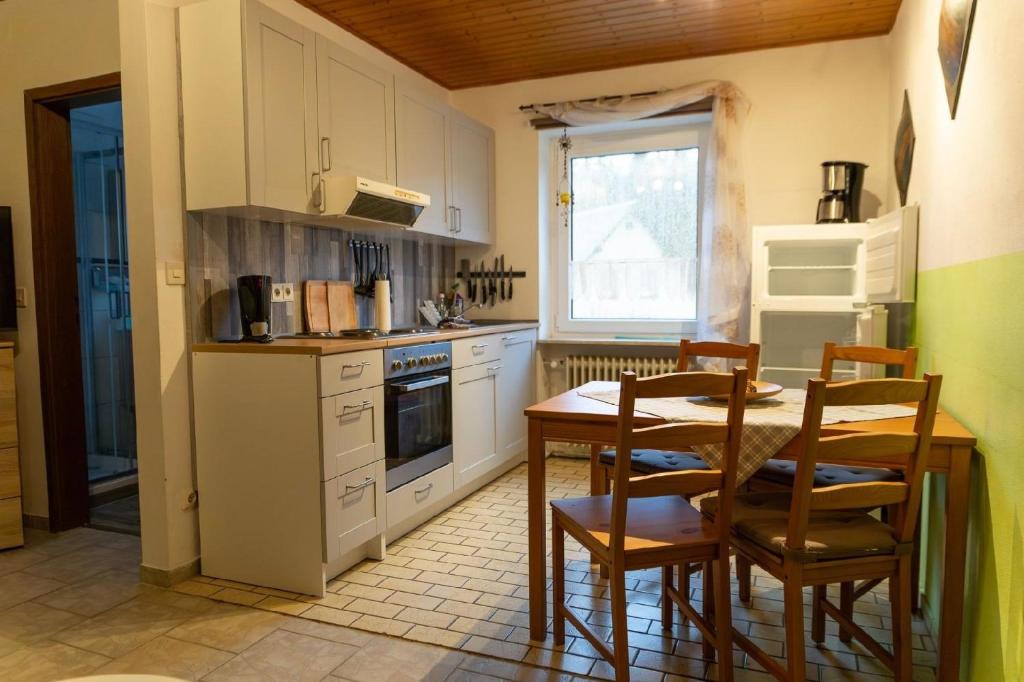 eine Küche mit einem Tisch und Stühlen in der Unterkunft Ferienwohnung auf einem Reiterhof in Weißenstadt